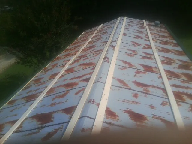 Rusted metal roof panels with new wood purlins before replacement — Storm Damage Roof Repair in Boxford by Roofing Brothers