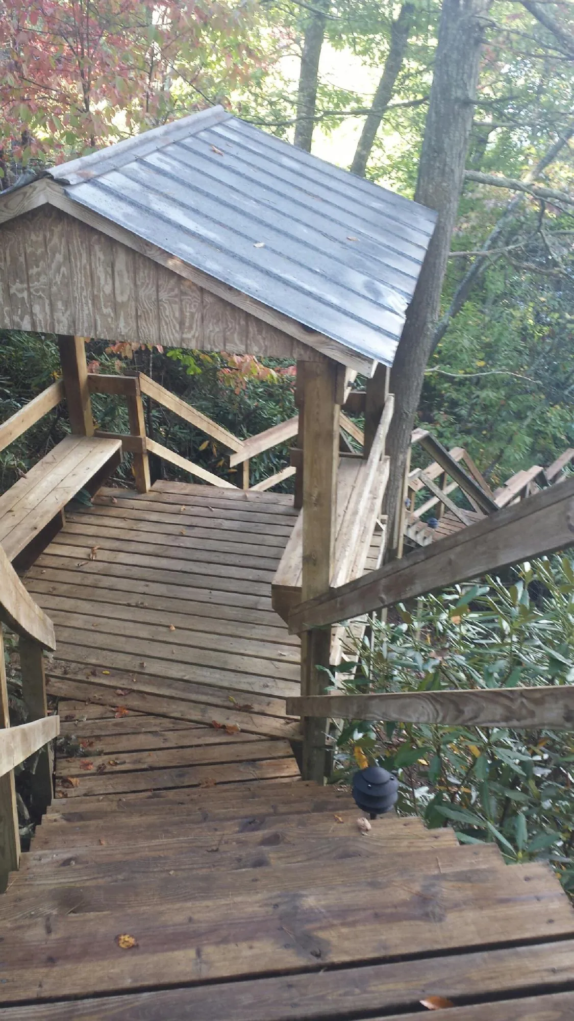 Metal roofed shelter over wooden steps on a wooded walkway — Skylight Repair & Installation work by our crew in Boxford