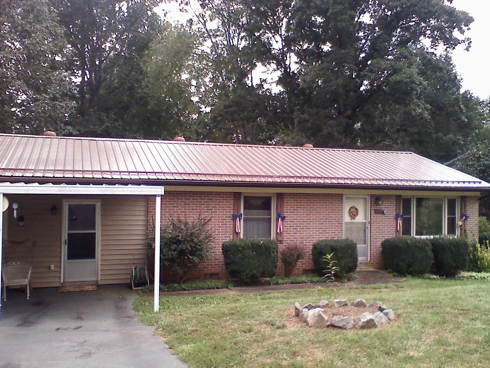 Bronze metal roof and carport on a brick ranch home — Roof Repair work by our crew in Boxford